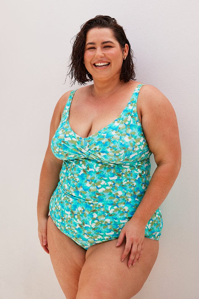 Brunette plus size women wears blue high waisted bikini bottom