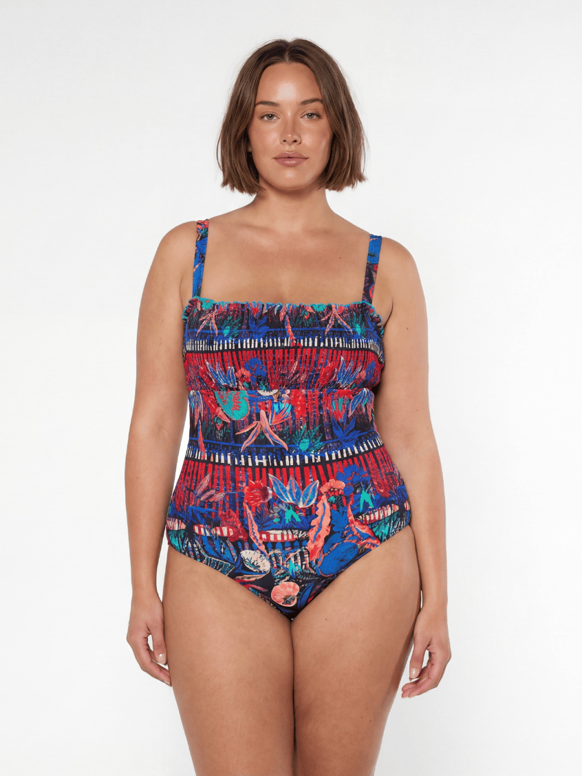 Woman wearing a colorful patterned swimsuit on a white background