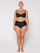 Woman wearing a black bikini set on a white background