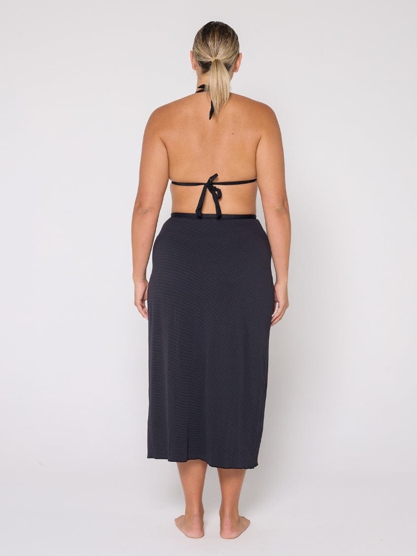 Woman wearing a black halter top and skirt on a white background