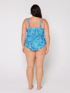 Woman wearing a blue floral swimsuit against a white background