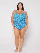 Woman wearing a blue floral swimsuit against a white background