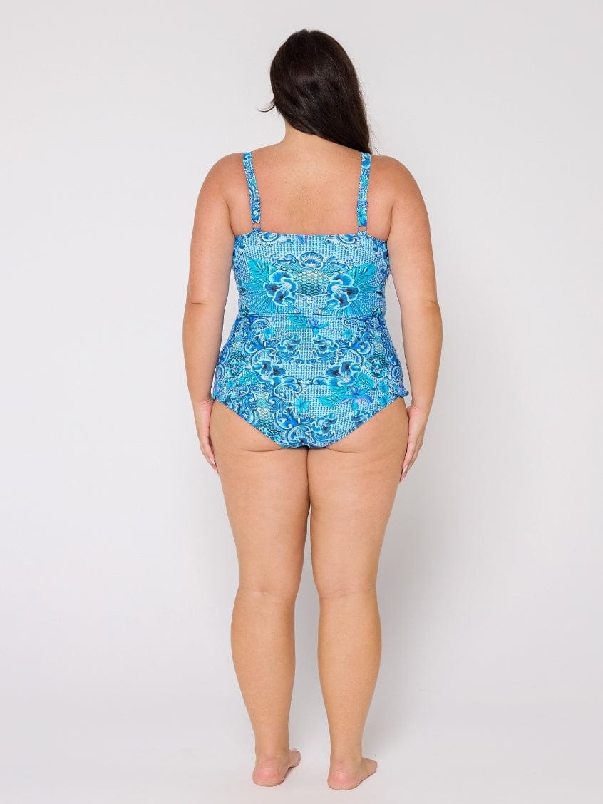 Woman wearing a blue patterned swimsuit on a white background