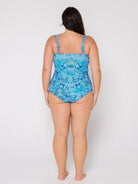 Woman wearing a blue patterned swimsuit on a white background