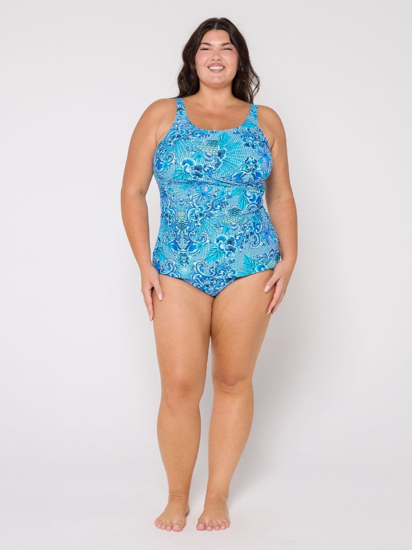 Woman wearing a blue patterned swimsuit on a white background