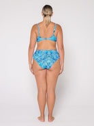 Woman wearing a blue patterned bikini set on a white background
