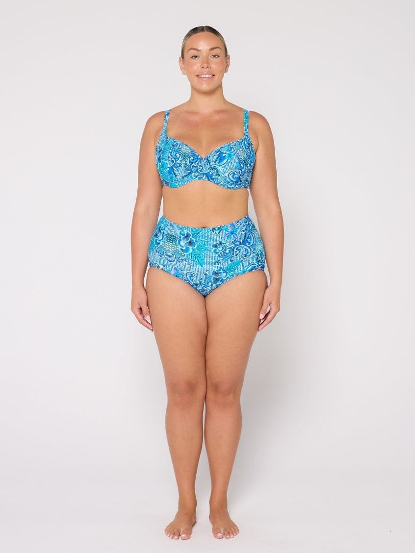 Woman wearing a blue patterned bikini set on a white background