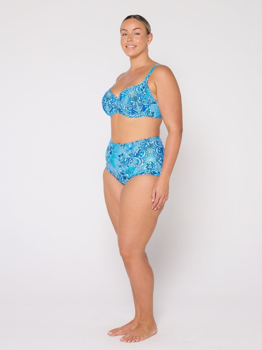 Woman wearing a blue floral bikini set on a white background