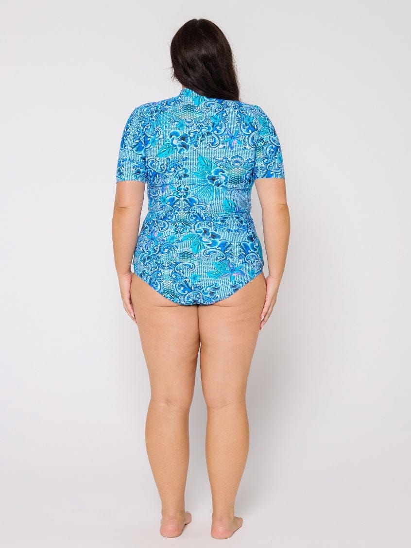 Person wearing a blue patterned swimsuit on a white background
