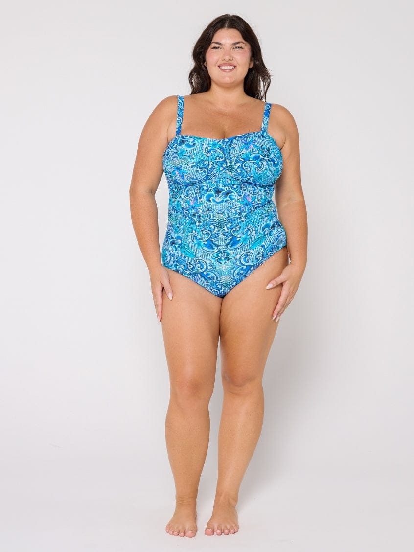 Woman wearing a blue patterned swimsuit on a white background
