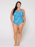 Woman wearing a blue patterned swimsuit on a white background