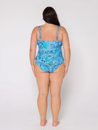 Woman wearing a blue patterned swimsuit on a white background