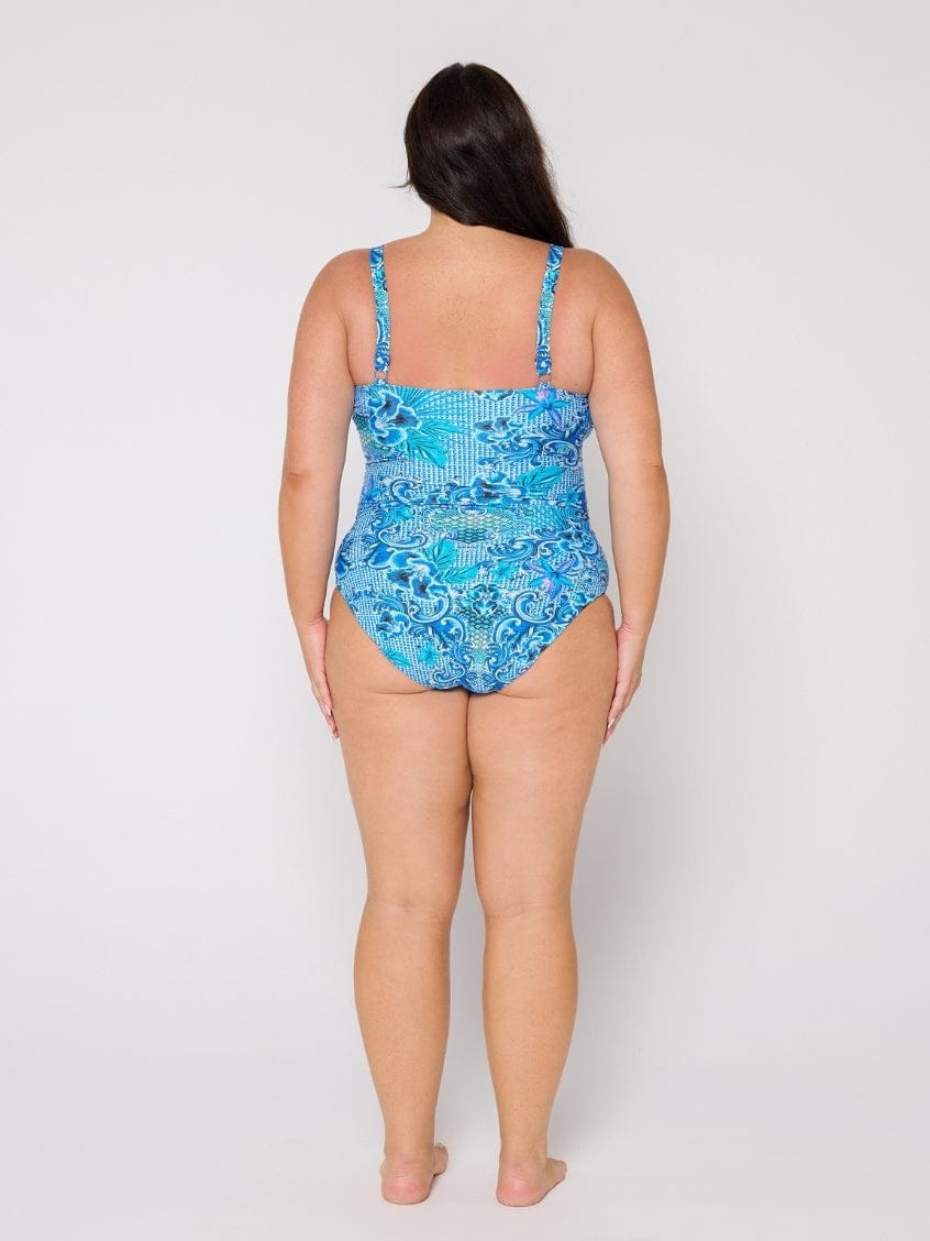 Woman wearing a blue patterned swimsuit on a white background