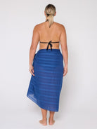 Woman wearing a blue striped sarong on a white background