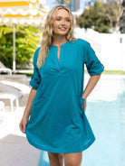 Woman wearing a teal dress by a poolside