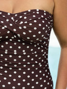 Brown strapless top with white polka dots on a blurred background