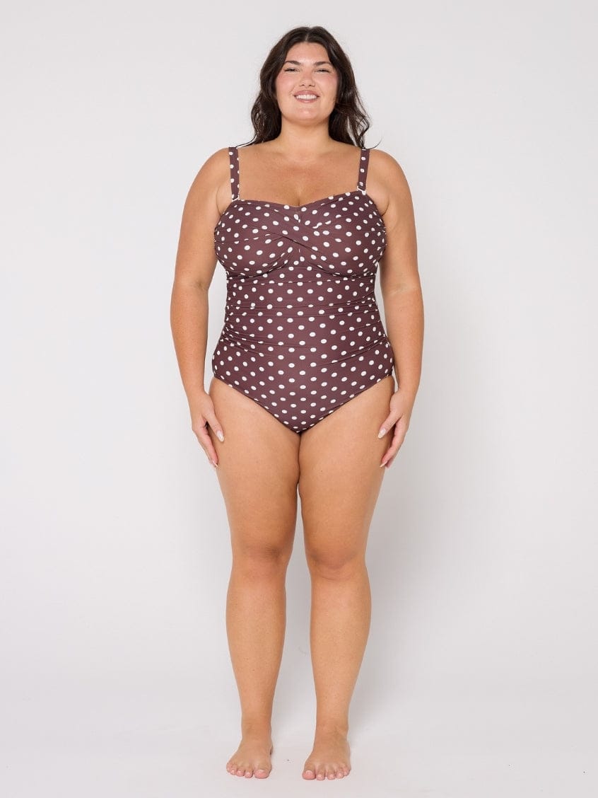 Woman wearing a polka dot swimsuit on a white background