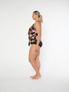 Woman wearing a floral two-piece swimsuit on a white background