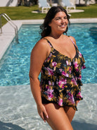 Woman in a floral swimsuit standing by a pool