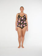Woman wearing a floral one-piece swimsuit on a white background