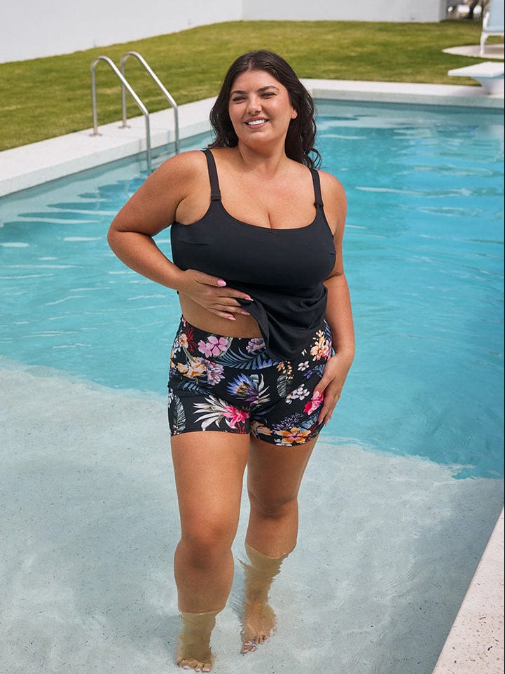 Woman in black tank top and floral shorts standing in a pool