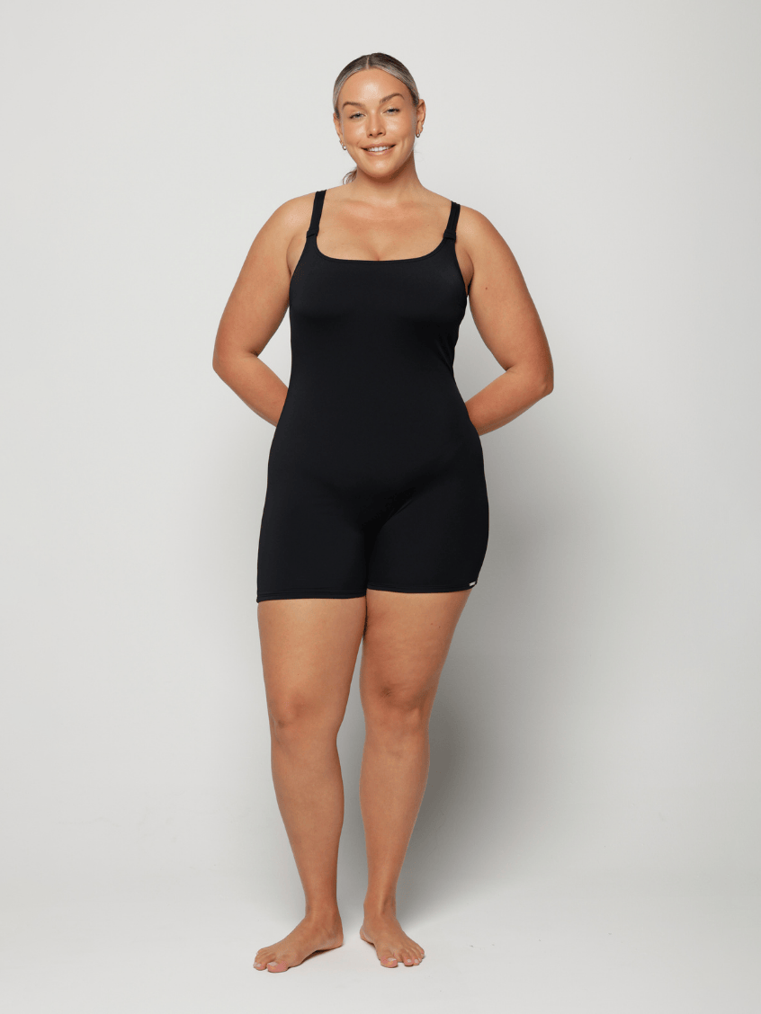 Person wearing a black chlorine resistant bodysuit against a white background