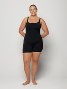 Person wearing a black chlorine resistant bodysuit against a white background