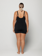 Person wearing a black chlorine resistant boyleg swimsuit on a plain background