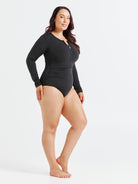 Black chlorine-resistant long sleeve one piece swimsuit with zip front and UPF 50+ sun protection, shown on model standing side on