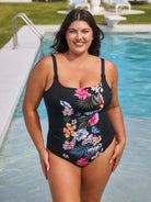 Woman wearing a black floral swimsuit by a pool