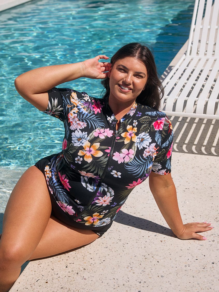 Woman in a floral swimsuit by a pool