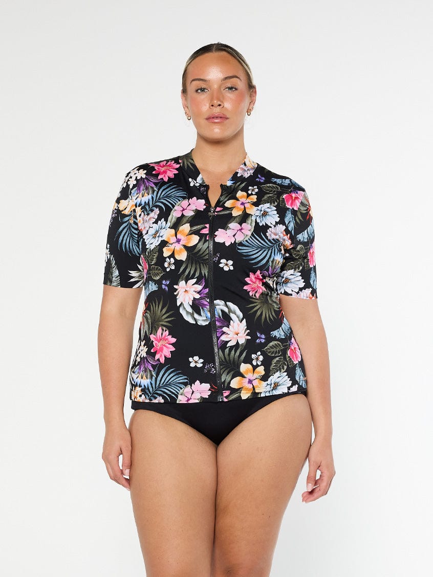 Blonde model shows front of chlorine resistant short sleeve rashie in black floral print