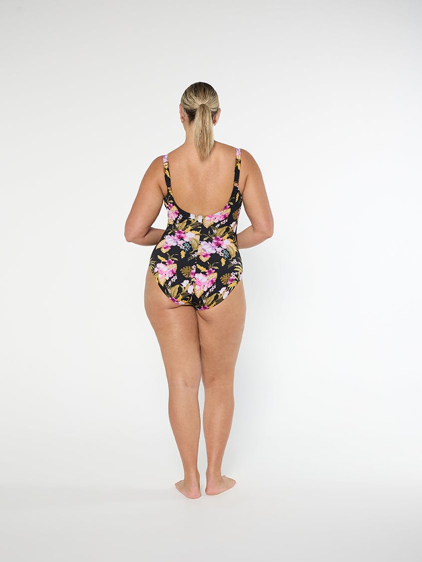 Woman wearing a floral one-piece swimsuit on a white background