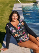 Woman in a floral swimsuit sitting by a pool