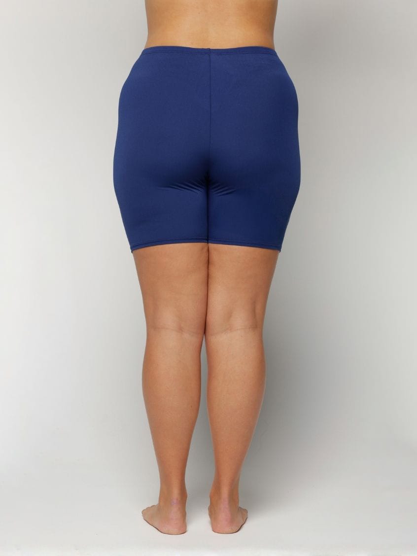 Person wearing blue shorts on a plain background with chlorine resistant fabric
