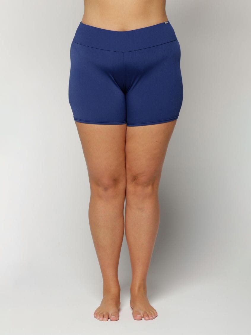 Person wearing blue swim shorts on a plain background