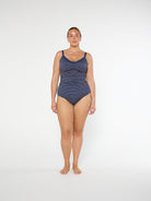 Woman wearing a blue patterned swimsuit on a white background