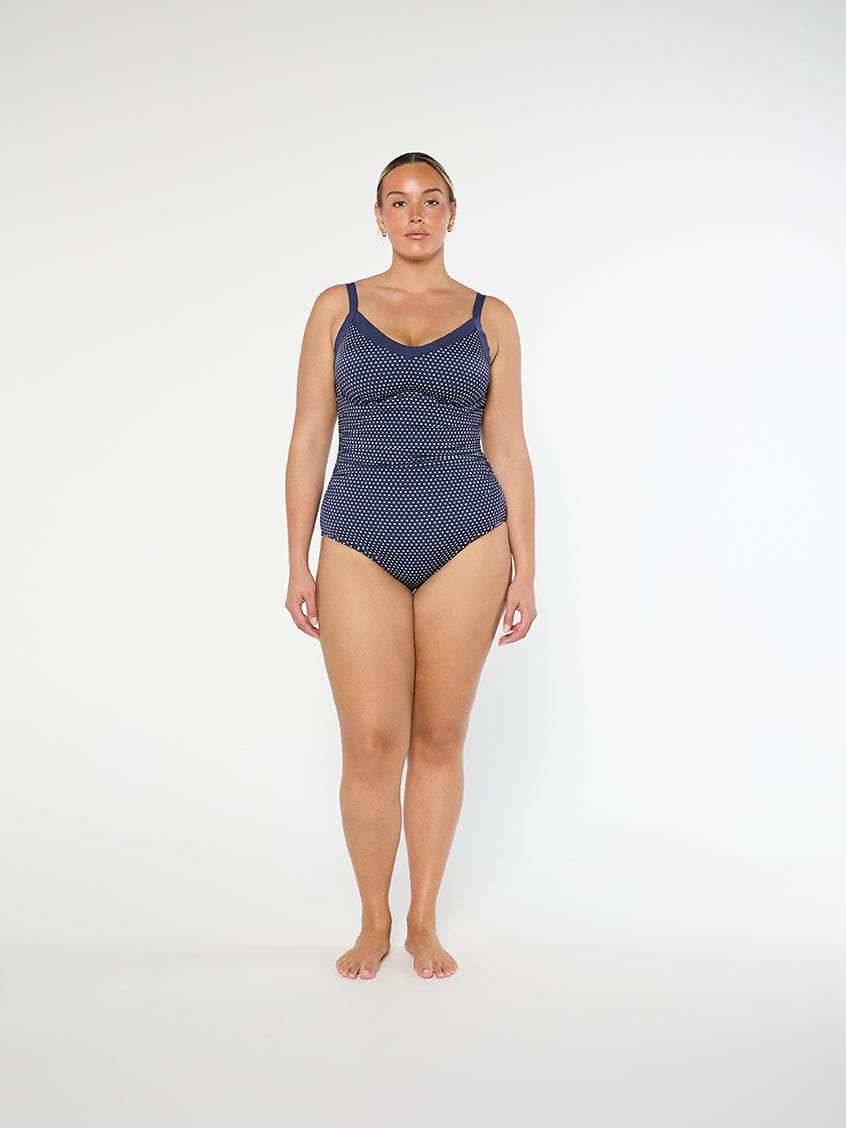 Woman wearing a blue patterned swimsuit on a white background