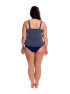 Woman wearing a navy blue polka dot swimsuit on a white background