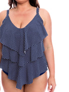 Woman wearing a navy blue tank top with white polka dots on a white background