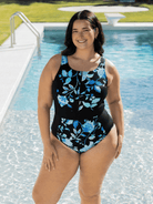 Woman wearing a black floral swimsuit by a pool in chlorine resistant