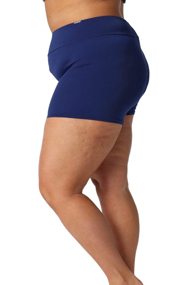 Model showing side of navy boyleg swim shorts