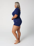 Woman wearing a navy blue outfit on a white background