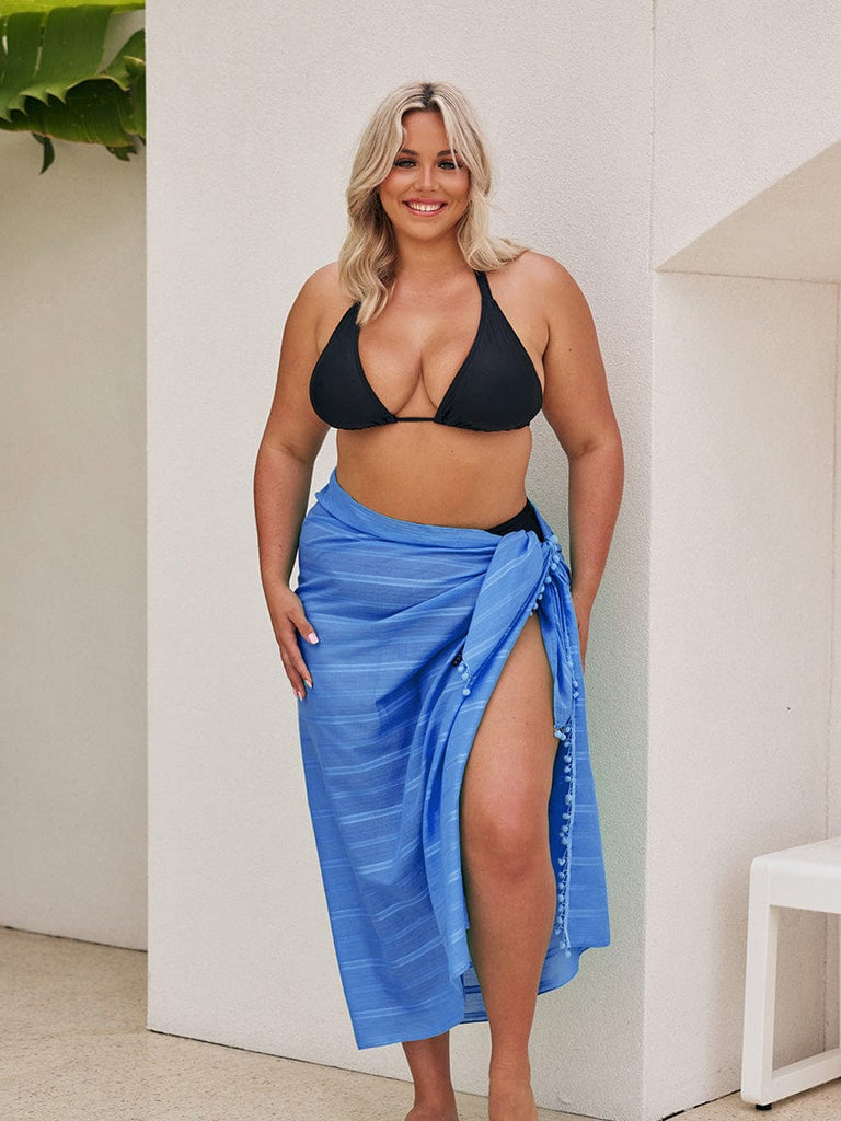 Blonde model wearing a long cotton sarong coverup with pom poms