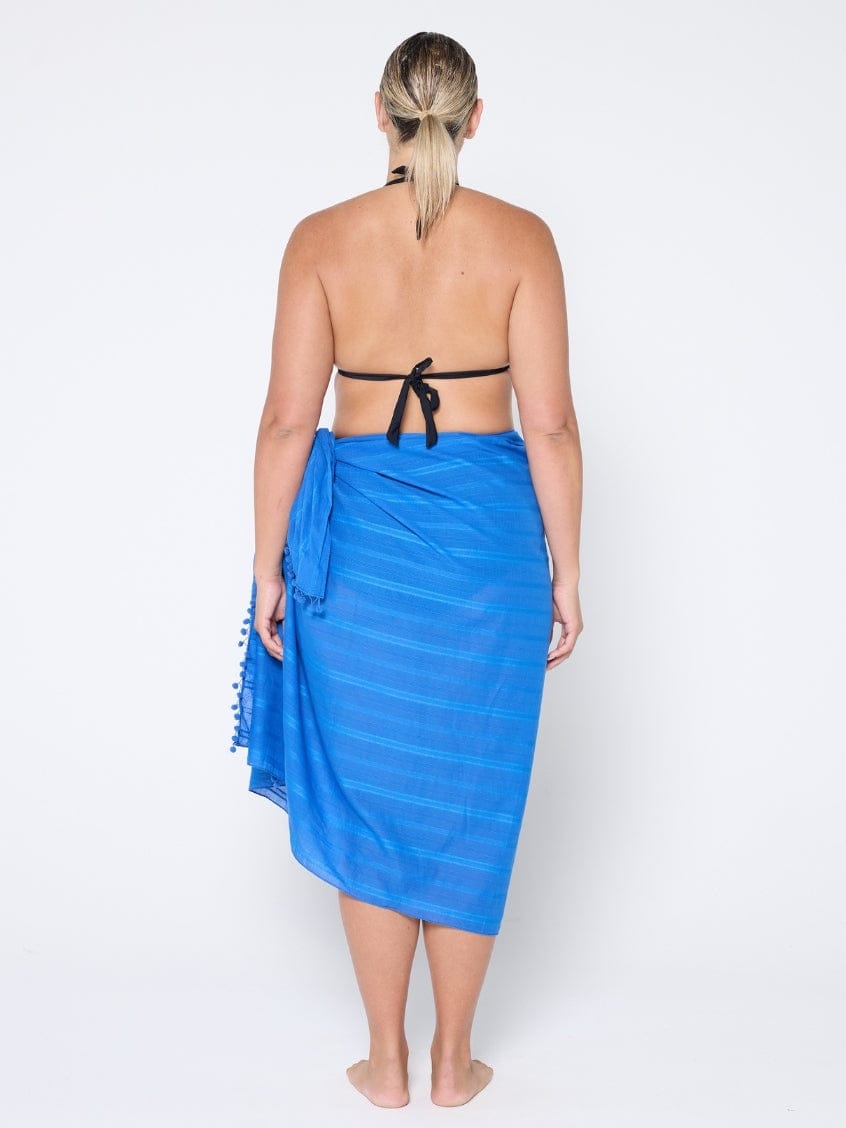 Person wearing a blue sarong on a white background