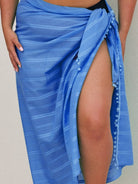 Blue sarong with a slit draped over a person on a neutral background