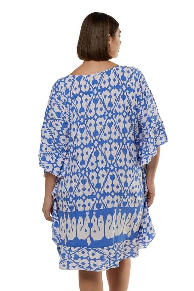 back profile of model in powder blue and white block printed knee length dress