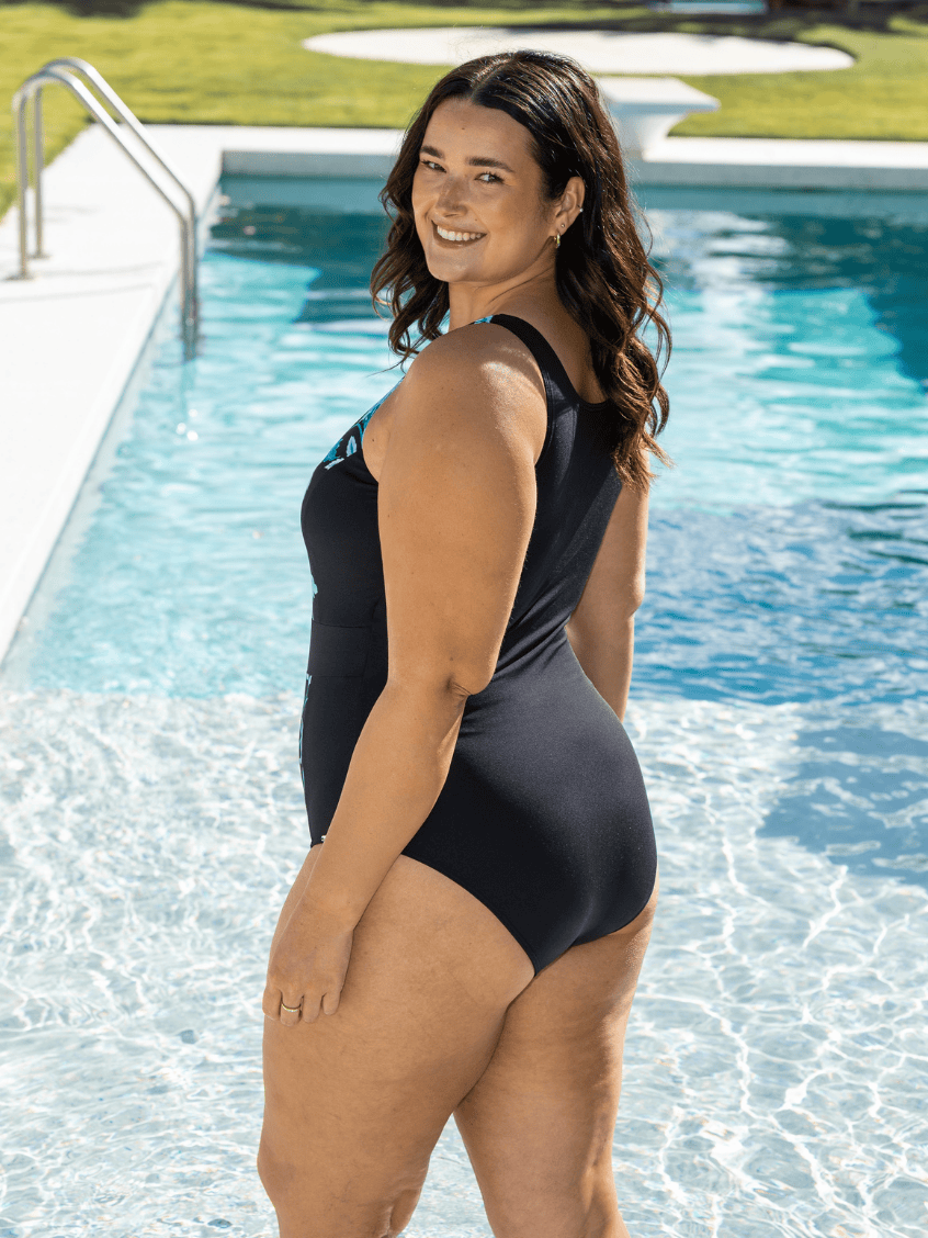 Woman in pool wearing a chlorine resistant zip front one piece with high back.