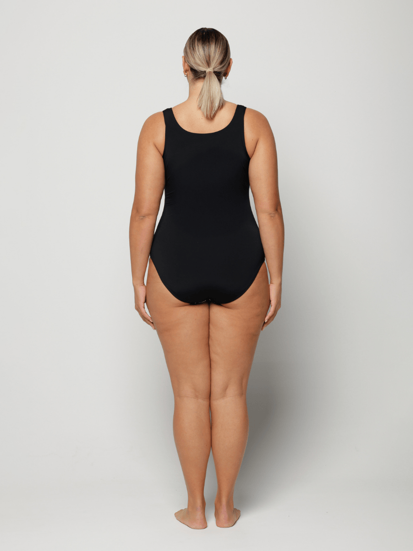 Person wearing a black swimsuit against a white background