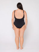 Woman wearing a black swimsuit on a white background